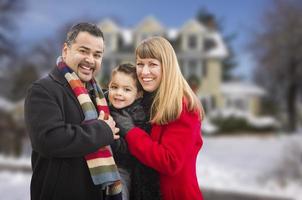 blandad lopp familj i främre av hus i de snö foto