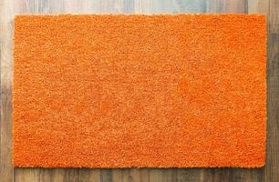 tom orange Välkommen matta på trä golv bakgrund redo för din egen text foto