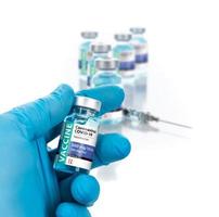 läkare eller sjuksköterska bär kirurgisk handske innehav coronavirus covid-19 vaccin injektionsflaska foto