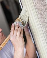 professionell målare skärande i med borsta till måla hus dörr ram. foto