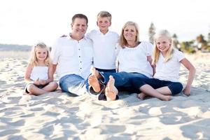 Lycklig caucasian familj porträtt på de strand foto