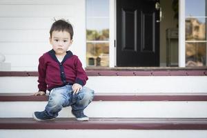 melankoli blandad lopp pojke Sammanträde på främre veranda steg foto