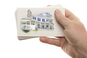 manlig hand innehav stack av blixt kort med hus teckning foto