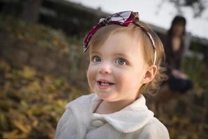 förtjusande bebis flicka spelar i parkera med mamma foto