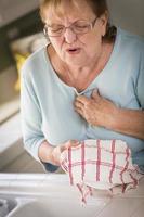 senior vuxen kvinna på handfat med bröst möda foto