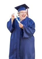 Lycklig senior vuxen kvinna examen i keps och klänning innehav diplom isolerat på en vit bakgrund. foto