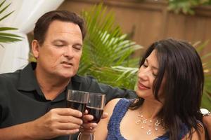 attraktiv latinamerikan och caucasian par dricka vin foto