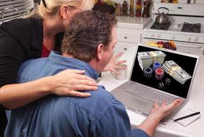 par i kök använder sig av bärbar dator - uppkopplad poker foto