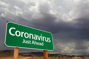 coronavirus grön väg tecken mot olycksbådande stormig molnig himmel foto