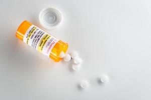 icke-proprietär medicin recept flaska och spillts piller över huvud foto