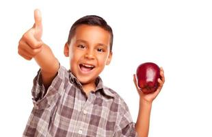 förtjusande latinamerikan pojke med äpple och tummen upp hand tecken foto
