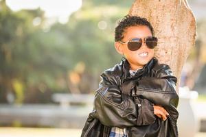 afrikansk amerikan och mexikansk pojke klädd upp med solglasögon och läder jacka foto