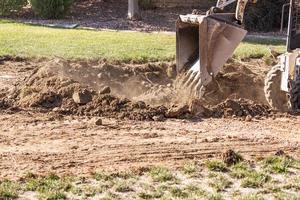 små bulldozer grävning i gård för slå samman installation foto