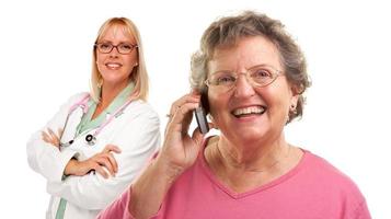 senior kvinna använder sig av cell telefon med kvinna läkare Bakom foto