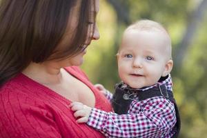 liten bebis pojke har roligt med mamma utomhus foto