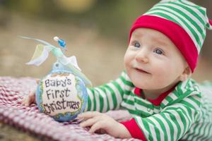 spädbarn bebis på filt med babys först jul prydnad foto