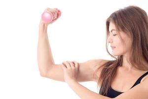 ung flicka som handlar om med de sport klamrar sig fast till de biceps på hand isolerat vit bakgrund foto
