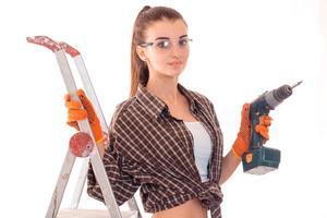 ung brunett lady byggare gör renovering isolerat på vit bakgrund foto