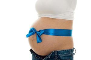 närbild av gravid kvinna med stor mage och blå tejp på den isolerat på vit bakgrund foto