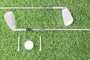 golfklubba och golfboll på grönt gräs foto