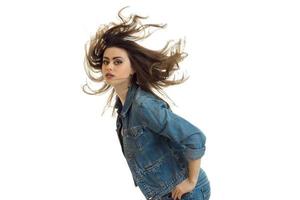 attraktiv ung flicka står lutande framåt- och henne hår flyga genom de luft foto