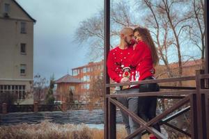 porträtt av härlig par kramar på en balkong vinter- tid. xmas humör foto