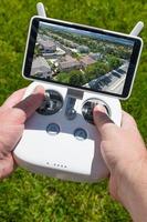 händer innehav Drönare quadcopter kontrollant med bostads- hem på skärm foto
