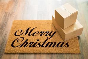 glad jul Välkommen matta på trä golv med sändning av lådor foto