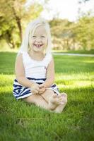 söt liten flicka Sammanträde och skrattande i de gräs foto
