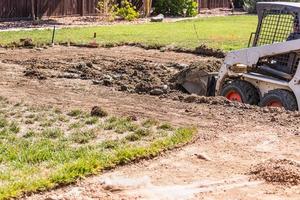 små bulldozer grävning i gård för slå samman installation foto