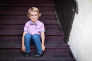söt ung caucasian pojke porträtt Sammanträde på trappsteg steg foto