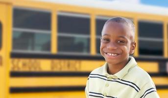 ung afrikansk amerikan pojke nära skola buss foto