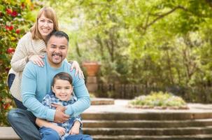 blandad lopp latinamerikan och caucasian familj porträtt på de parkera foto