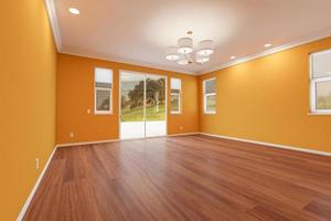 nytt ombyggt rum av hus med färdiga trä golv, gjutning, gul ockra måla och tak lampor. foto