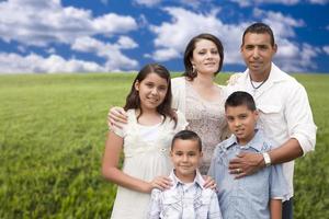 latinamerikan familj porträtt stående i gräs fält foto