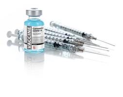 coronavirus covid-19 vaccin injektionsflaska och flera sprutor på reflekterande yta foto