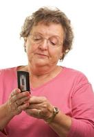 senior kvinna använder sig av cell telefon foto