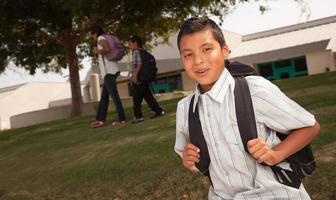 Lycklig ung latinamerikan pojke redo för skola foto