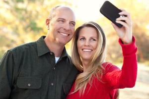attraktiv par utgör för en själv porträtt utomhus foto