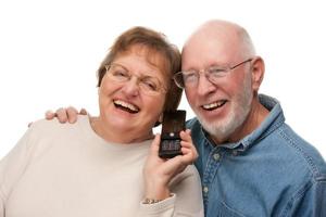 Lycklig senior par använder sig av cell telefon foto