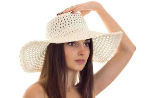 porträtt av ett attraktiv flicka i en hatt med en stor brätte som utseende mot isolerat på vit bakgrund foto