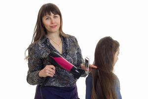 mor gör en frisyr till henne ung dotter foto