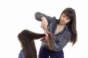 kvinna gör en frisyr till en liten flicka foto