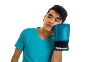 allvarlig brunett sportsman i blå boxning handskar och enhetlig praktiserande boxning isolerat på vit bakgrund foto