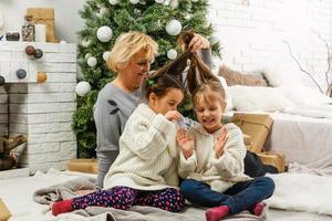 farföräldrar och barn har roligt under jul dag firande på Hem med familj foto