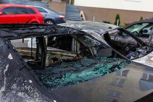 två bilar efter de brand. två bränt ut bilar med ett öppen huva. mordbrand, bränd bil foto