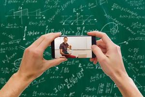 man använda sig av mobil telefon, oskärpa bild av klassrum är tömma som bakgrund. foto