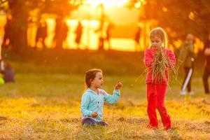 förtjusande liten flickor har roligt spelar utomhus på sommar dag foto