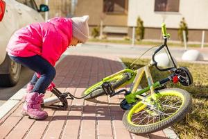 en liten flicka pumps upp en cykel däck. foto