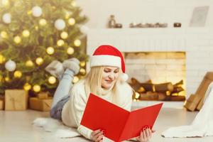 kvinna läsning bok nära jul träd foto